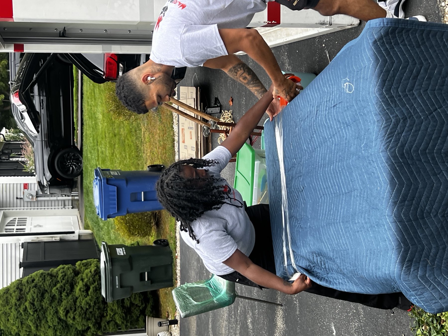 Major Movers crew protecting furniture with a moving blanket and stretch wrap