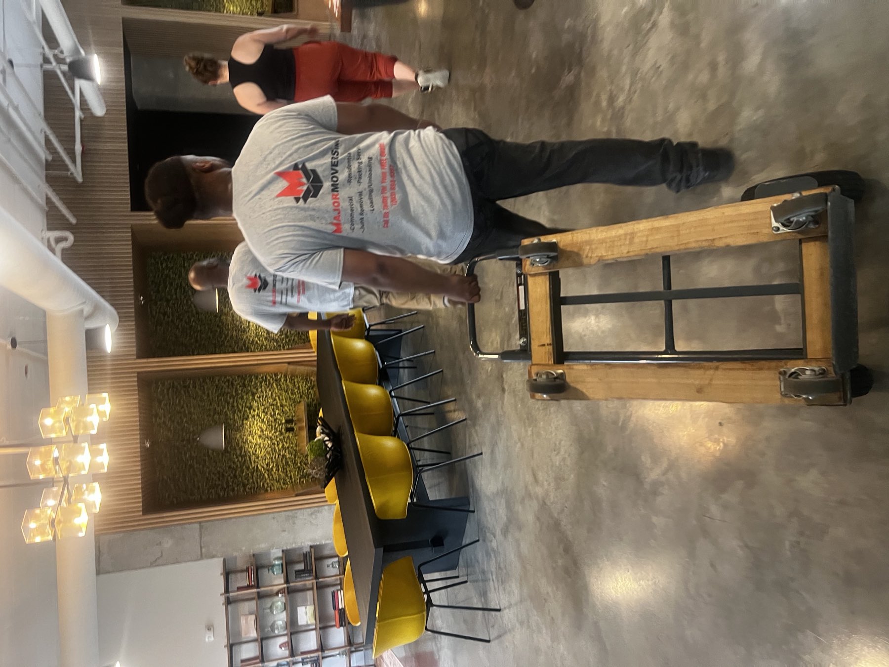 Major Movers crew moving office furniture with a dolly
