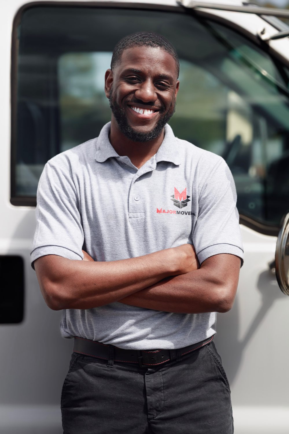 A Major Movers team member in a branded polo in front of a Major Movers truck