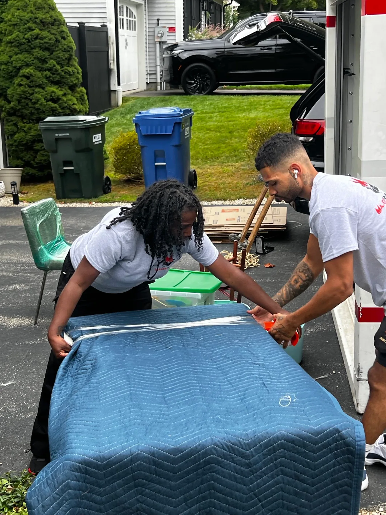 Major Movers crew protecting furniture with a moving blanket and stretch wrap