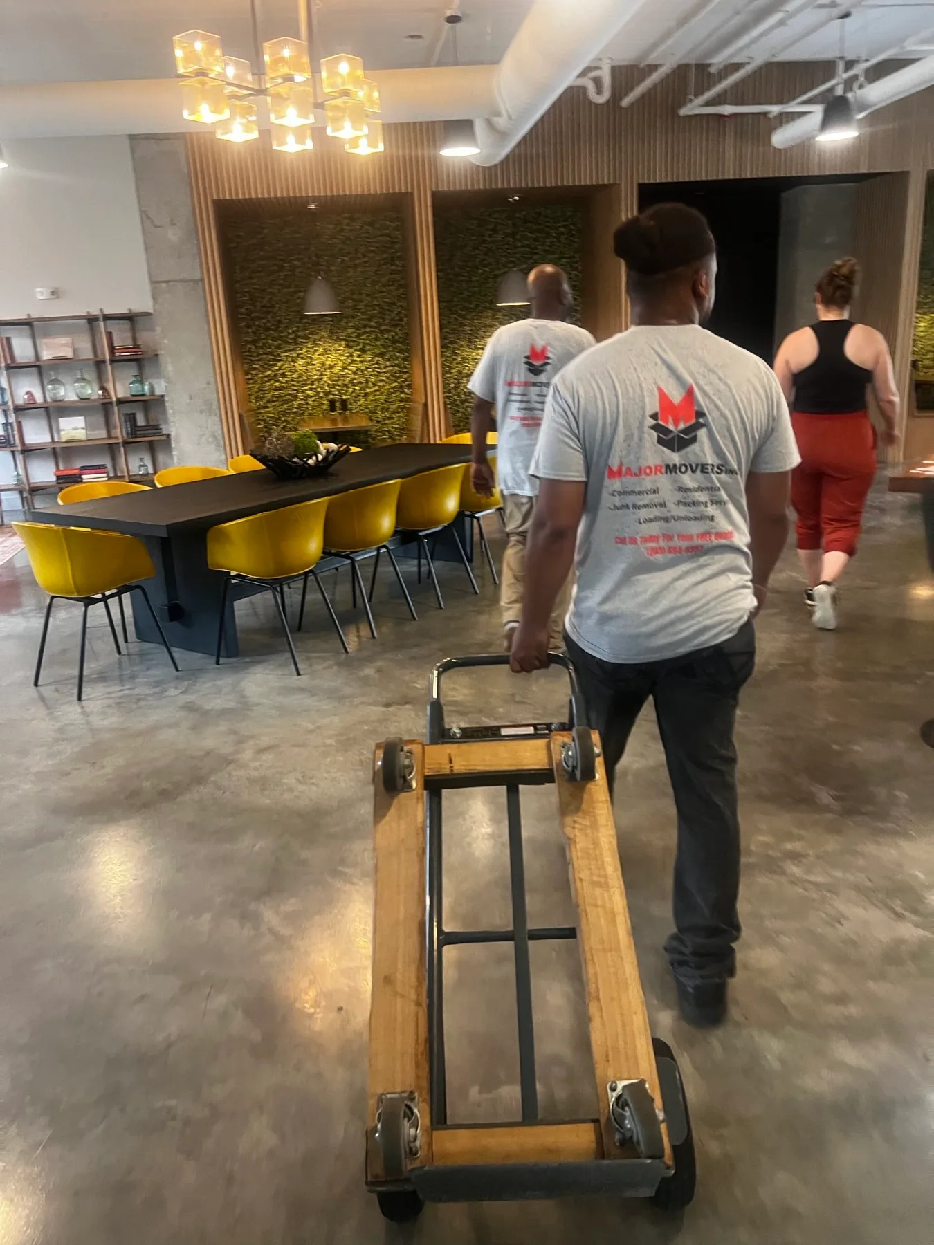 Major Movers crew moving office furniture with a dolly